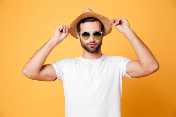 Concentrated young man standing isolated over yellow background - Photo, image