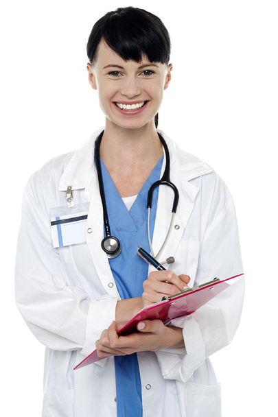 Friendly doctor updating medical record of a patient - Foto, imagen