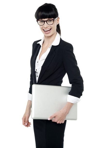 Cheerful office employee holding laptop - Foto, afbeelding