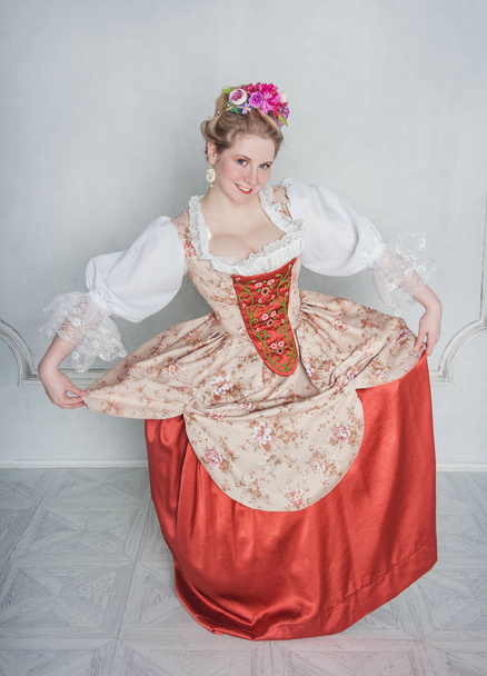 Όμορφη γυναίκα σε ντεμοντέ μεσαιωνικό φόρεμα κάνοντας υπόκλιση - Φωτογραφία, εικόνα