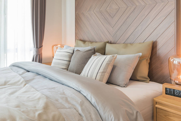 set van kussens op bed met houten wanddecoratie in klassieke stal - Foto, afbeelding