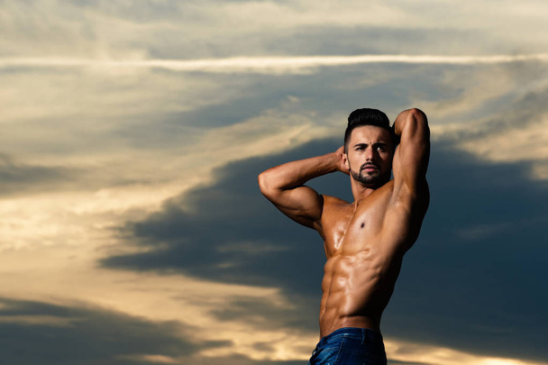 athlete man with muscular body on blue sky - Fotoğraf, Görsel