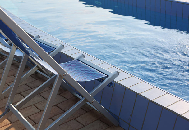 deck chairs on the pool edge of the spa without people - Photo, Image