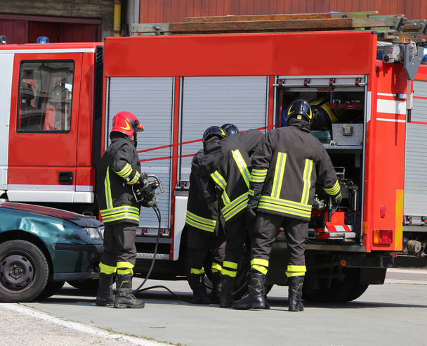 Brandweerauto's en brandweerlieden met uniformen en beschermende helm - Foto, afbeelding