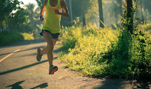 Mujer joven corriendo por sendero forestal
 - Foto, imagen