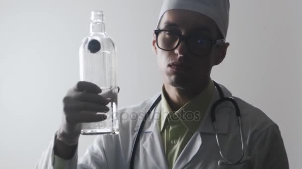 Πορτραίτο του γιατρού μεθυσμένος. Ένα ιατρικό εργαζόμενο ποτά βότκα. - Πλάνα, βίντεο