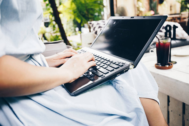 Крупним планом жінки використовують ноутбук, сидячи в кафе
 - Фото, зображення