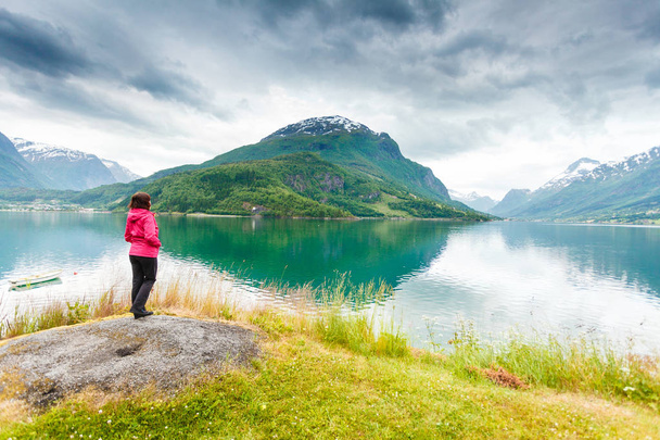 Woman tourist relaxing on fjord sea shore, Norway - Foto, afbeelding