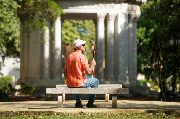 Sokea mies istuu kaupungin puistossa ja lepää
 - Valokuva, kuva