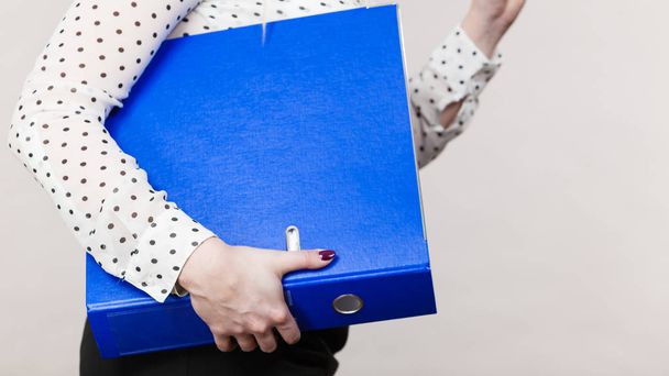 Woman holding blue binder with documents - 写真・画像