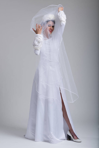 young bride in a wedding dress with a veil - Fotó, kép