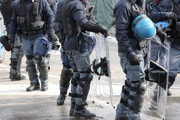通りをパトロールしながらヘルメットの暴動鎮圧用装備の警察 - 写真・画像
