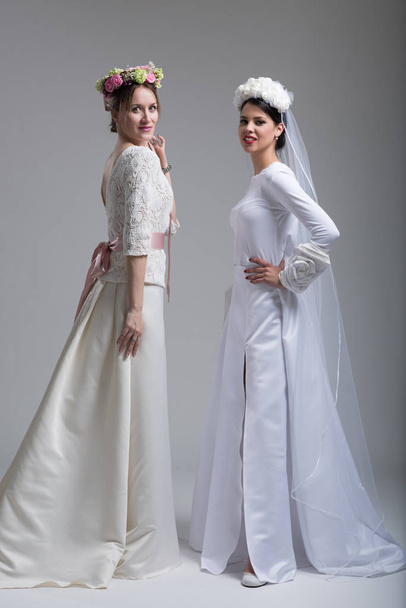 Portrait of two beautiful young brides in wedding dresses - Fotoğraf, Görsel