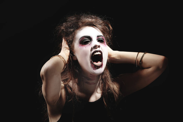 Young woman in color contact lenses, with Halloween makeup on black background - Φωτογραφία, εικόνα
