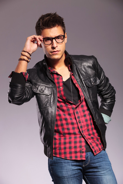 man in leather jacket and jeans holding his glasses - Photo, Image