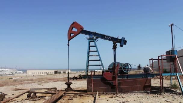Pompes à huile dans un champ pétrolifère en marche à Bakou, Azerbaïdjan. Silhouette de pompe à huile en marche sur fond de ciel bleu et de nuages.
 - Séquence, vidéo