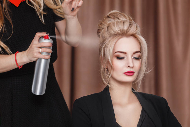 Cabeleireiro profissional usando spray de cabelo no cliente cabelo mulher de negócios no salão de beleza
 - Foto, Imagem