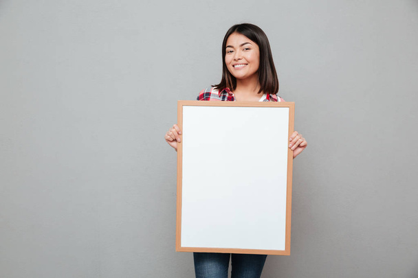Happy young asian woman holding copyspace blank. - 写真・画像