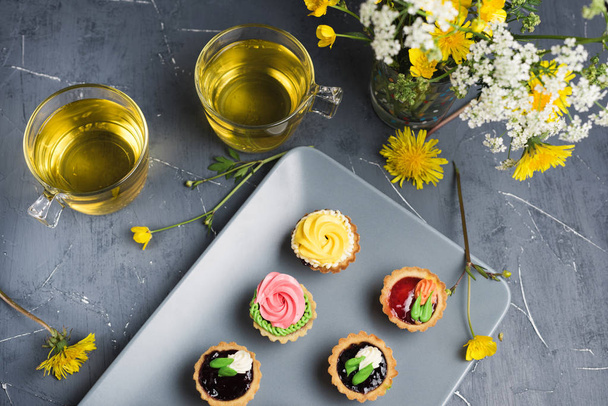 Cupcake colorati su piatto e tavolo grigio
 - Foto, immagini
