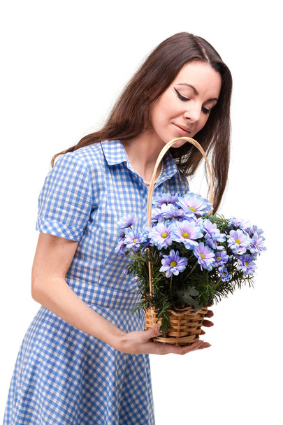 Piękna dziewczyna w sukience w niebieski koszyk z kwiatów chrysanthe - Zdjęcie, obraz