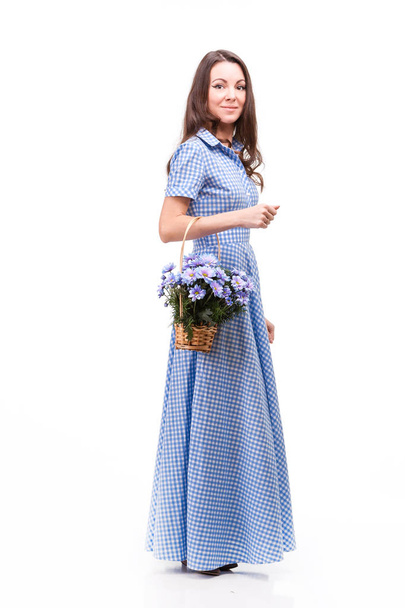 Hermosa chica en un vestido en una jaula azul con flores chrysanthe
 - Foto, Imagen