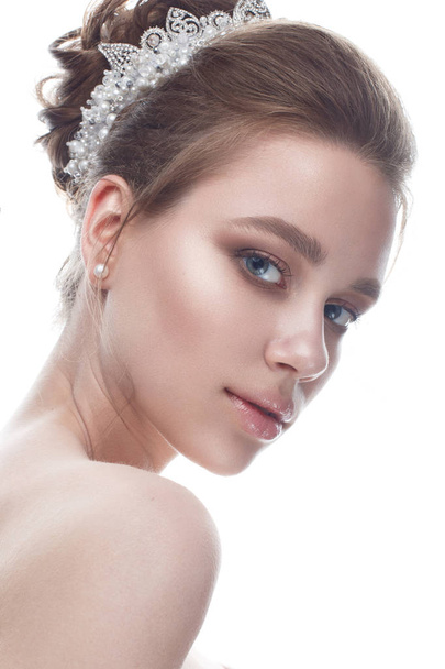 A young girl in a gentle wedding image with a diadem on her head. Beautiful model in the image of the bride on a white isolated background with nude makeup. Pure shining skin.  - 写真・画像