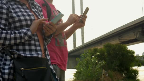Les femmes et l'homme sur la rue dactylographier du texte avec un téléphone mobile
 - Séquence, vidéo