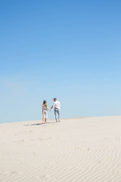 Όμορφο ζευγάρι στην αγάπη στον ορίζοντα της λευκής άμμου - Φωτογραφία, εικόνα