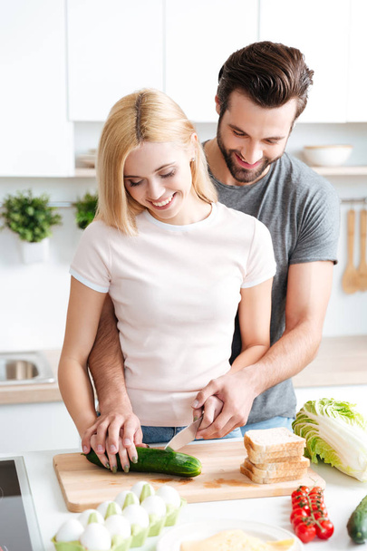 portrait de heureux jeune couple cuisiner ensemble dans la cuisine - Photo, image