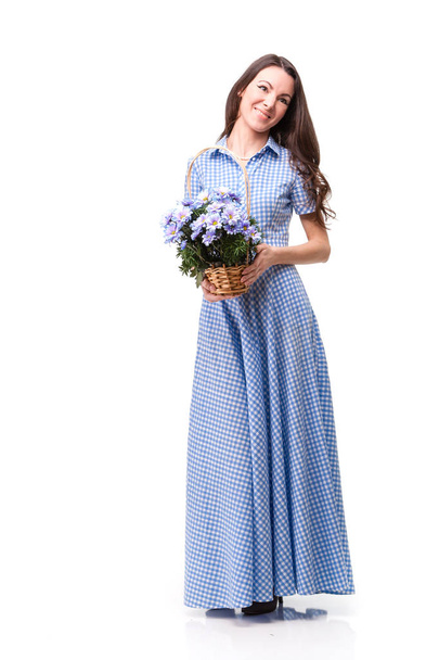 Όμορφο κορίτσι σε ένα φόρεμα σε ένα μπλε κλουβί με λουλούδια Χρυσάνθη - Φωτογραφία, εικόνα
