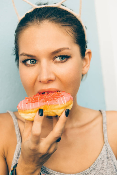 Sexy brunette lady eat sweet heart shaped donut. - Fotó, kép