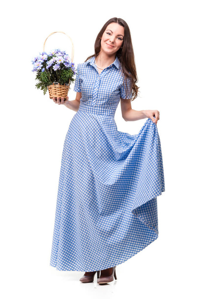 Όμορφο κορίτσι σε ένα φόρεμα σε ένα μπλε κλουβί με λουλούδια Χρυσάνθη - Φωτογραφία, εικόνα