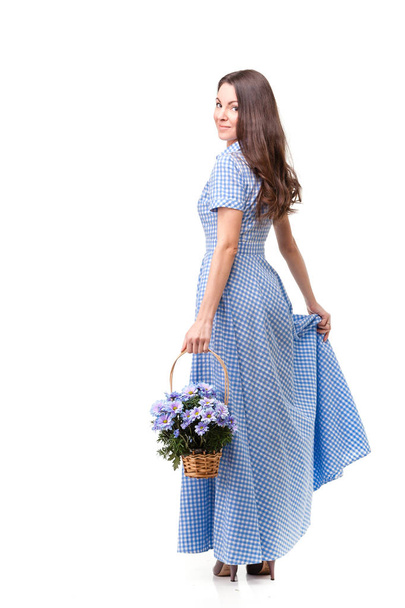 Beautiful girl in a dress in a blue cage with flowers chrysanthe - Фото, изображение