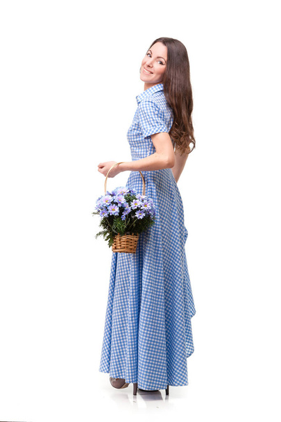 Beautiful girl in a dress in a blue cage with flowers chrysanthe - Fotografie, Obrázek