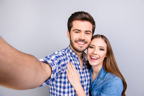 Close up of a cheerful young couple making selfie photo on guy`s - Foto, Imagen