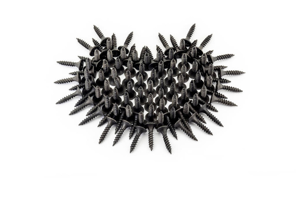 Favorite men's activities. Black heart with thorns laid out whit black screws on white background - Фото, изображение