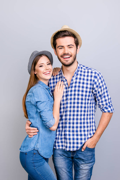 Vacation together. Happy young couple in casual wear and hats ar - Foto, imagen