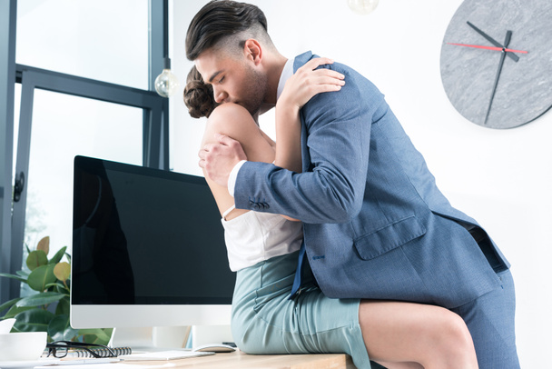 business colleagues kissing in foreplay at workplace - Foto, Bild