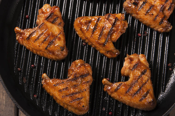 Gebakken kippenvleugels gril op de barbecue pan - Foto, afbeelding