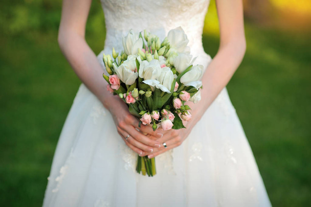 Gelin bir güzel beyaz düğün buket tutuyor - Fotoğraf, Görsel