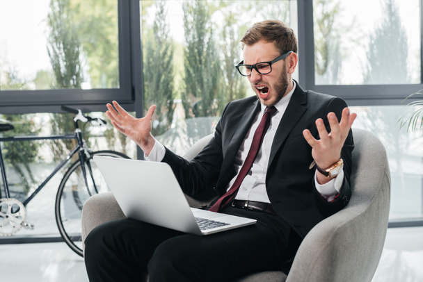homem de negócios irritado gritando enquanto trabalhava no laptop
 - Foto, Imagem