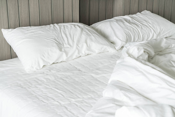 rumpled bed with white messy pillow decoration in bedroom  - Foto, immagini