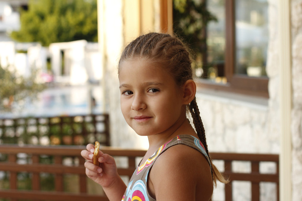 Маленька дівчинка з печивом в руці
 - Фото, зображення