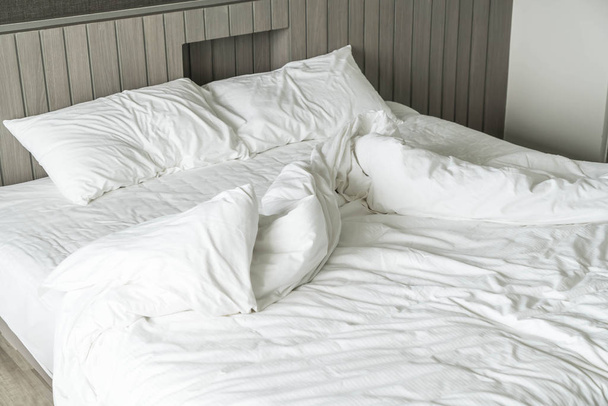 rumpled bed with white messy pillow decoration in bedroom  - Foto, imagen