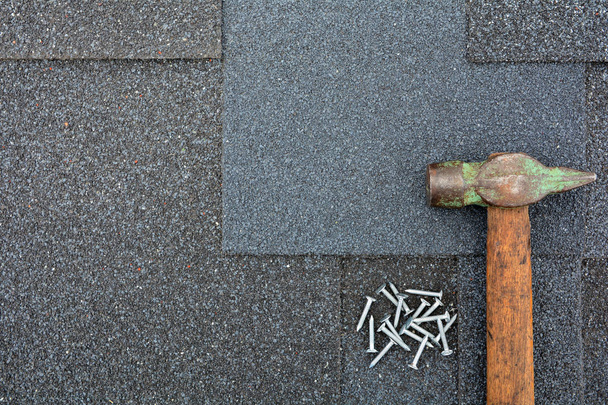 Close-up op asfalt dakbedekking Shingles achtergrond. Dakshingles - dakpannen. Asfalt dakshingles hamer en nagels - Foto, afbeelding