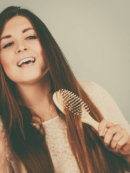Happy woman brushing her hair - Photo, image