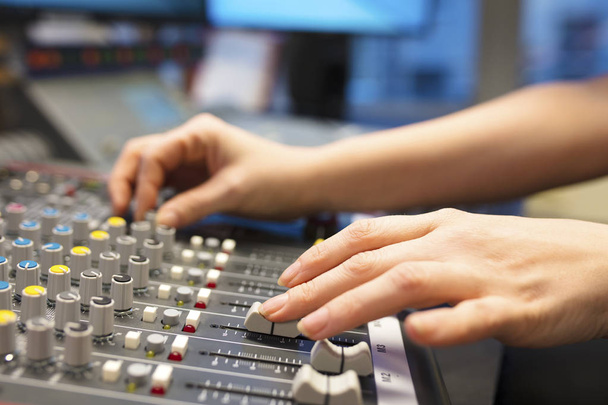 Animateur de radio féminin utilisant le mélangeur de musique dans le studio
 - Photo, image