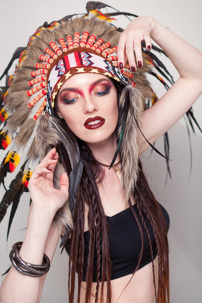 Indianerin mit traditionellem Make-up und Kopfbedeckung, die zur Seite schaut. Indianerin mit einer Kakerlake auf dem Kopf - Foto, Bild