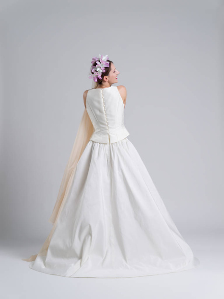 Rear view of a beautiful young woman in a wedding dress - Foto, Bild