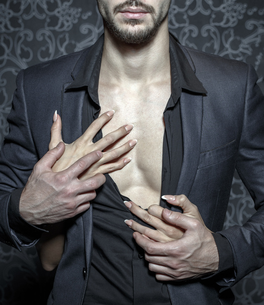 Сексуальний стильний багатий чоловік, роздягнений жінкою руками крупним планом
 - Фото, зображення